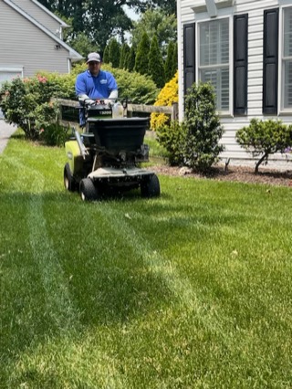 AgroLawn technician applying treatment to a lawn